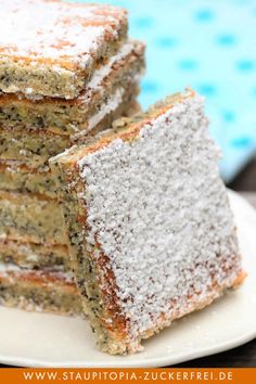 several pieces of cake on a plate with powdered sugar over them and the rest of the cake in the background