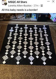 a black and white quilt on the floor