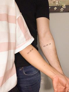 two people holding hands with tattoos on their arms and the words love are written in cursive letters