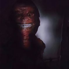 an image of a creepy person in the dark with his face painted red and black