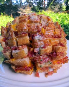 a white plate topped with waffles covered in cheese and bacon next to trees