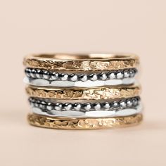 Introducing The Demi Stack, a set of seven unique and beautiful stacking rings that are perfect for making a bold statement. Made with mixed metals in gold fill and sterling silver, each ring features a different texture, from raw silk to mirror hammered. Mix and match them to create your own unique look. Whether you're dressing up or dressing down, these rings are sure to add a touch of edge and coolness to any outfit. USA sizes 4-12. Made with high quality materials, these rings are built to last. The set includes 3 14K yellow gold fill heavy weight "Raw Silk" stackers, 2 sterling silver "Dot" stackers, and 2 Sterling silver "Mirror" stackers. So whatever your style, you're sure to find the perfect combination with this set. PRODUCT DETAILS & MEASUREMENTS: - 100% Handmade in the USA. - M Rings In Gold, Ring Bands, Golden Jewelry, Monogram Jewelry, Gold Filled Ring, Mixed Metals, Raw Silk, Stackable Rings, Stacking Rings