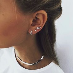 a close up of a person with ear piercings on their ears and wearing a white t - shirt