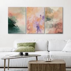 a living room with two paintings on the wall and a coffee table in front of it