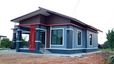 a small blue house sitting on top of a dirt field