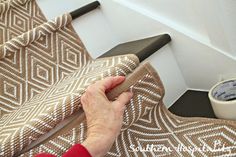 an elderly woman is cleaning the stairs with a cloth on top of her hand and a cup of coffee next to it