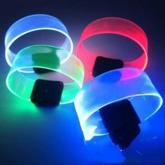 three glowing wristbands on a black background