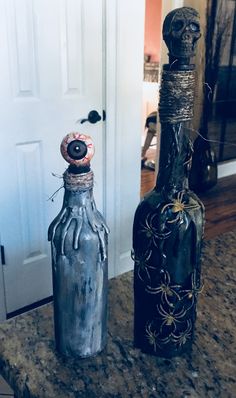 two bottles sitting on top of a counter next to each other in front of a door