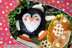 a penguin made out of food on top of a plate with oranges and carrots