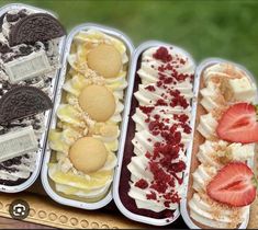 an assortment of desserts in trays sitting on a table