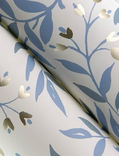 blue and white wallpaper with gold leaves on it