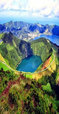 a large lake surrounded by green hills and water