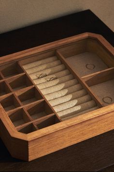 a wooden box with compartments filled with rings