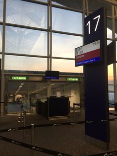 an airport terminal with the number 17 on it's sign in front of large windows