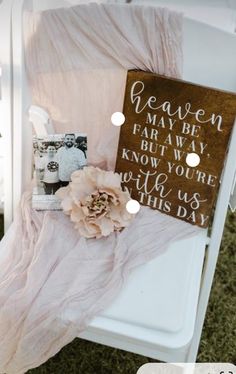 a white chair with a sign and flowers on top of it next to some other items