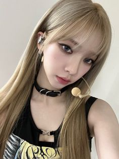 a woman with long blonde hair wearing a black choker and piercings on her ears