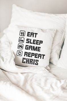 a pillow that says eat sleep game repeat christ on it sitting on top of a bed