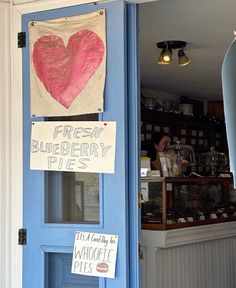 there is a blue door with some signs on the front and back doors that say fresh blueberry pies