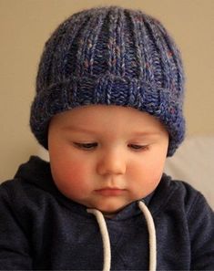 a small child wearing a blue knitted hat