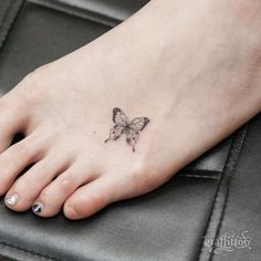 a small butterfly tattoo on the foot