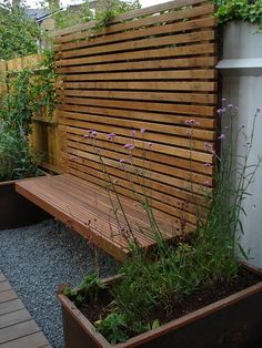 a wooden bench sitting next to a planter filled with flowers