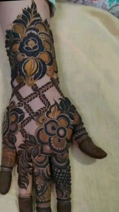 a woman's hand with henna tattoos on it