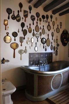 an old fashioned bathtub with lots of mirrors on the wall