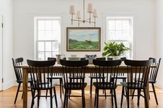 a dining room table with six chairs and a potted plant in the center area