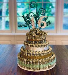 a cake made out of stacks of money on top of a wooden table next to a window