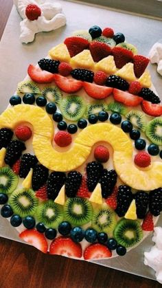 a decorated cake with fruit on it sitting on top of a pan