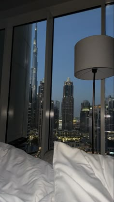 a bedroom with a view of the city at night