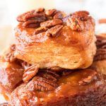 pecan pies stacked on top of each other with caramel sauce and pecans