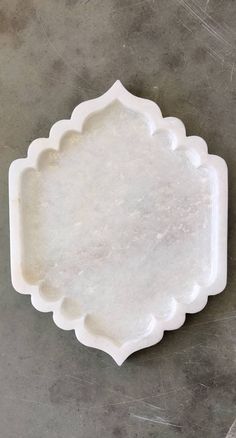 a white plate sitting on top of a cement floor next to a knife and fork