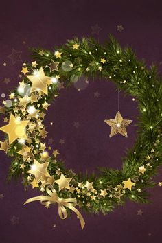 a christmas wreath with gold stars and ribbons hanging from the side on a purple background