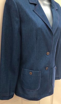 "Okay, this polyester blazer is awesome! It is faux denim in a stretchy polyester knit fabric. It is sized vintage 11/12, but by today's standards should fit a 6-8. See measurements below. This could be worn so many ways! The red stitching gives it western flare, but it also has a mod 70s vibe. I love it! It's in mint condition & hard to believe it's over 40 years old. Please note the vintage buttons ~ Remington Express 20GA. I've seen the buttons alone going for several dollars a piece. Sna Tailored Denim Blazer With Button Closure, Fitted Denim Blazer With Lapel Collar, Fitted Denim Blue Outerwear With Notch Lapel, Classic Denim Blazer With Buttons, Denim Blazer For Formal Fall Occasions, Denim Blazer For Formal Occasions In Fall, Formal Denim Blazer For Fall, Fitted Denim Jacket With Notch Lapel In Denim Blue, Fitted Denim Blue Denim Jacket With Notch Lapel