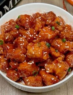 a white bowl filled with chicken and sesame seeds