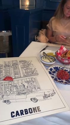 a woman sitting at a table with food in front of her