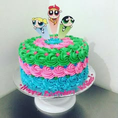 the cake is decorated with colorful frosting and has cartoon characters on top of it