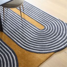 an area rug with wavy lines on the floor and a chair at the end in front of it