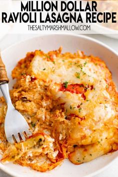 a white plate topped with lasagna covered in cheese and sauce next to a fork