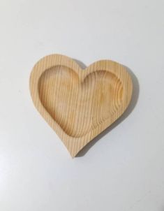 a wooden heart shaped dish sitting on top of a table