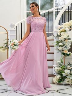 a woman in a pink dress standing on stairs