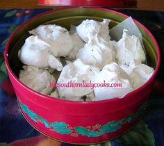 a pink bowl filled with white marshmallows on top of a table