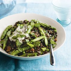 a white bowl filled with asparagus and lentils