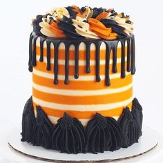 an orange and black striped cake with chocolate drips