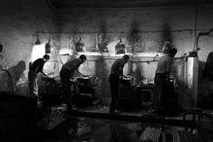 three men are working in an industrial kitchen