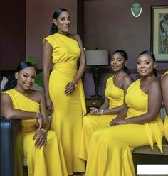 four women in yellow dresses posing for the camera