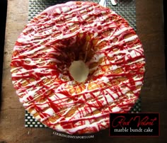 a donut covered in red and white icing on top of a wooden table