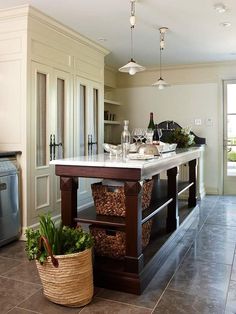 a kitchen island with wine glasses and bottles on it in front of an open door