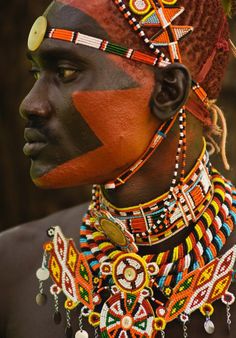 an african man with painted face and headdress